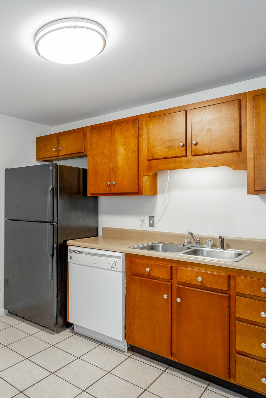 Kitchen of 2711 Banks Rd.  golden wood cabinets with dishwasher refrigerator and stove along the same wall.