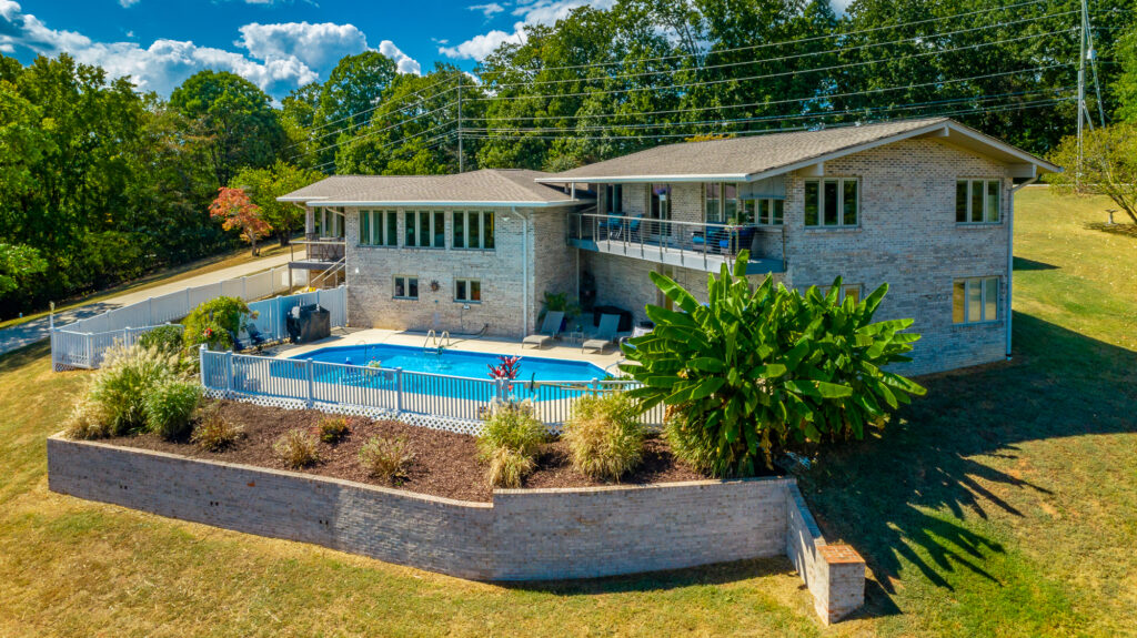 Back of 6530 Fairview Road a brick ranch home with inground pool on a hill