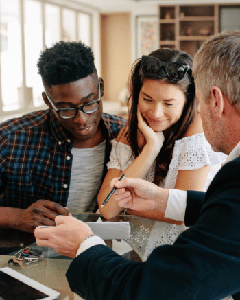 Working with a Realtor and agent walking a couple through paperwork